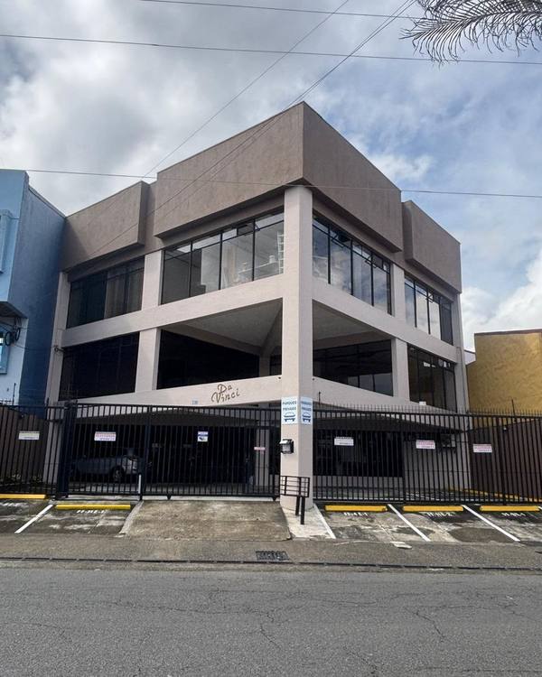 Edificio Da Vinci en San Pedro, donde está el consultorio, con portón negro y letreros de parqueo privado